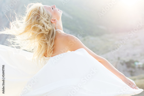Photo: Beautiful bride posing on the mountain Beautiful bride posing on the mountain