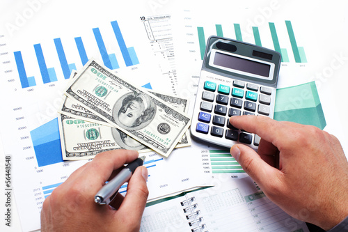 Photo: Hand with calculator and money. Hand with calculator and money.
