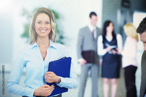 Photo: Bussinesswoman over team background Bussinesswoman over team background