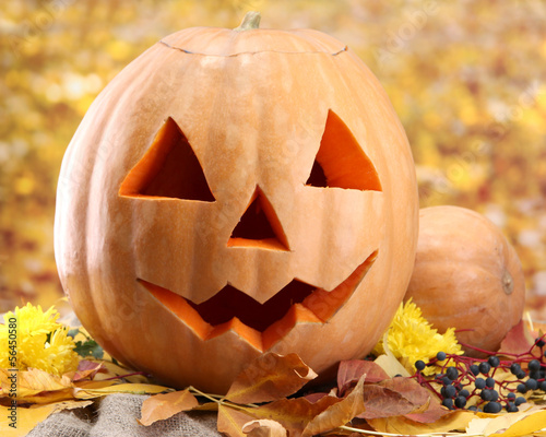 Photo: halloween pumpkins and autumn leaves, on yellow background halloween pumpkins and autumn leaves, on yellow background