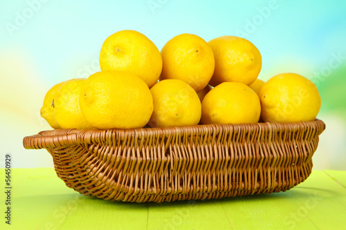Photo: Ripe lemons in wicker basket on table on bright background Ripe lemons in wicker basket on table on bright background