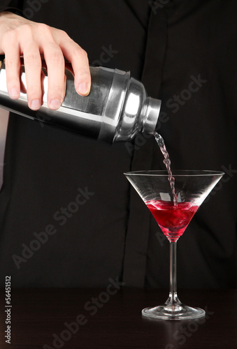Photo: Bartender making cocktail on close-up Bartender making cocktail on close-up