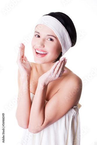 Photo: Happy woman is cleaning her face Happy woman is cleaning her face