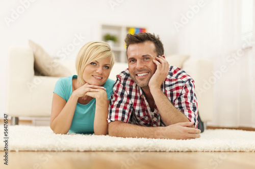 Photo: Portrait of loving couple on the floor in their house Portrait of loving couple on the floor in their house