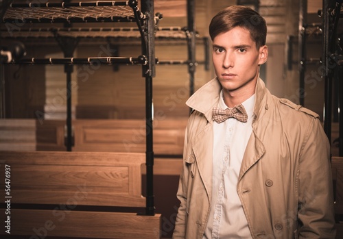 Photo: Handsome young man in coat inside vintage train Handsome young man in coat inside vintage train