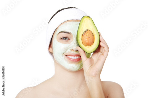 Photo: Young woman with a smile holding with avocado Young woman with a smile holding with avocado