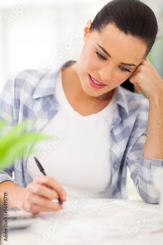 Photo: young woman filling her tax forms young woman filling her tax forms