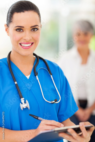 Photo: female doctor writing on clipboard female doctor writing on clipboard