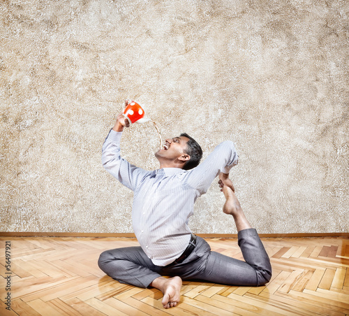 Photo: Businessman drinking tea in yoga pose Businessman drinking tea in yoga pose