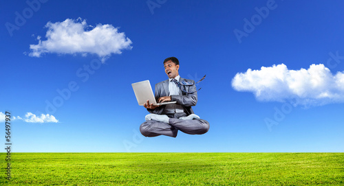 Photo: Businessman levitating with laptop Businessman levitating with laptop