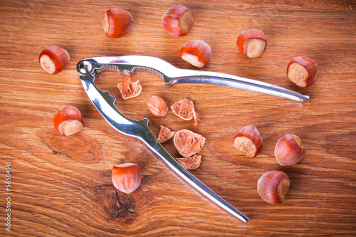 Photo: Hazelnuts with nutcracker on the wooden board Hazelnuts with nutcracker on the wooden board