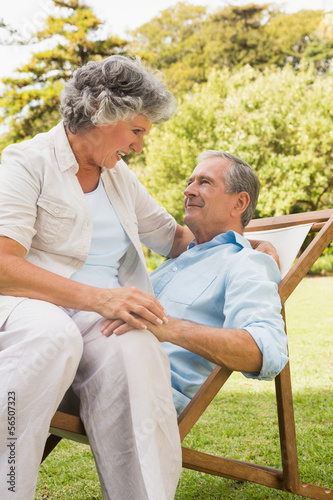 Photo: Happy mature couple sitting on sun lounger Happy mature couple sitting on sun lounger
