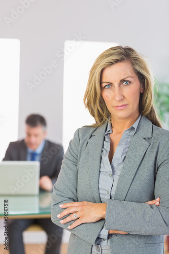 Photo: Serious businesswoman looking at camera crossed arms with a busi Serious businesswoman looking at camera crossed arms with a busi