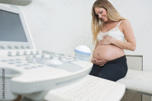 Photo: Woman Holding Tummy By Ultrasound Machine Woman Holding Tummy By Ultrasound Machine