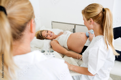 Photo: Doctors Performing An Ultrasound Procedure On Pregnant Woman Doctors Performing An Ultrasound Procedure On Pregnant Woman