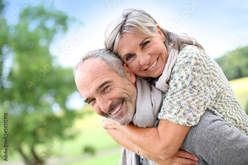 Photo: Senior man giving piggyback ride to woman Senior man giving piggyback ride to woman