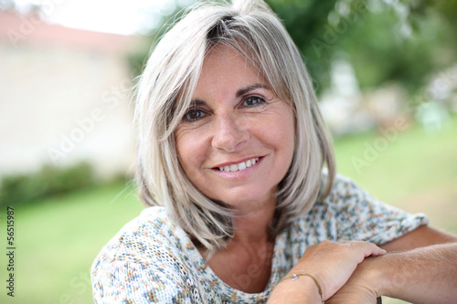 Photo: Portrait of serene mature woman in garden Portrait of serene mature woman in garden