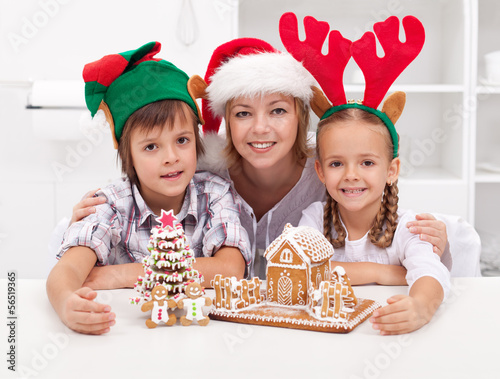 Photo: Happy family at christmas time with gingerbread house Happy family at christmas time with gingerbread house