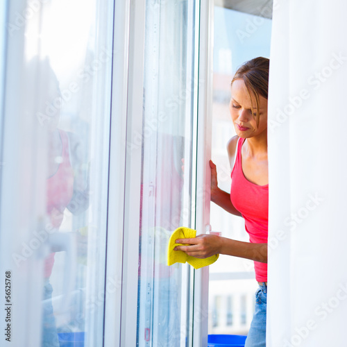 Photo: Pretty, young woman doing house work - washing windows Pretty, young woman doing house work - washing windows