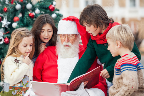 Photo: Santa Claus And Children Reading Book Santa Claus And Children Reading Book