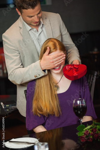 Photo: Handsome man offering present to his girlfriend Handsome man offering present to his girlfriend