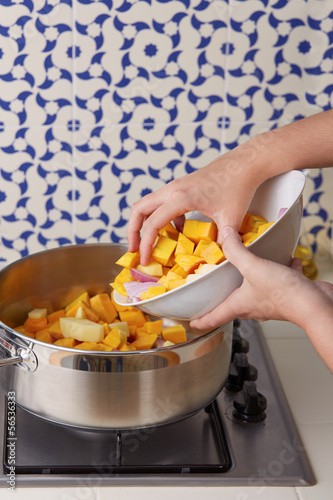 Photo: Hand pouring cut vegetables on a pan Hand pouring cut vegetables on a pan