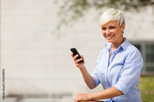 Photo: Portrait of blonde businesswoman with mobile phone Portrait of blonde businesswoman with mobile phone