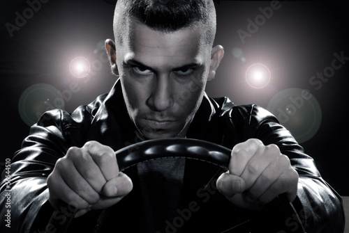 Photo: Hombre conduciendo un automóvil sujetando un volante. Hombre conduciendo un automóvil sujetando un volante.