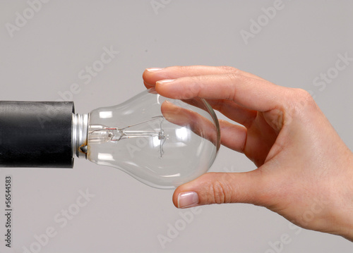 Photo: Mano sujetando una bombilla,cambiando bombillo Mano sujetando una bombilla,cambiando bombillo