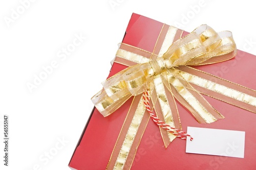 Photo: Red gift with a golden bow and tag isolated on white background Red gift with a golden bow and tag isolated on white background