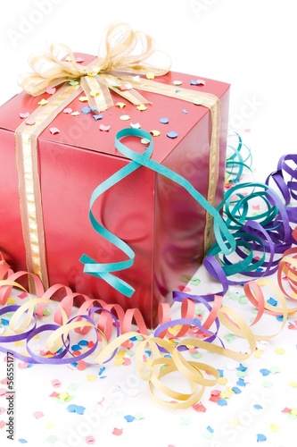 Photo: Red gift with a golden bow in a party setting Red gift with a golden bow in a party setting