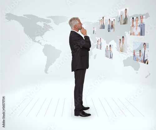 Photo: Mature businessman staring at futuristic interface Mature businessman staring at futuristic interface
