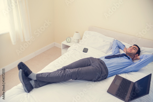Photo: Pleased man relaxing on his bed Pleased man relaxing on his bed