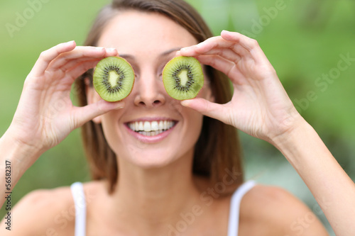 Photo: Cheerful girl showing kiwi slices Cheerful girl showing kiwi slices