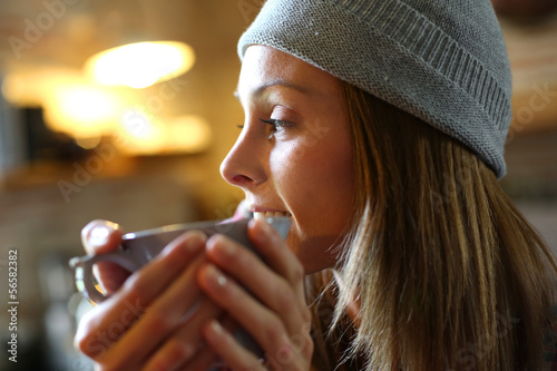 Photo: Trendy girl at home having hot drink Trendy girl at home having hot drink