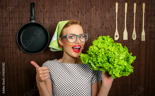 Photo: Happy woman cook with thumbs up holding salad Happy woman cook with thumbs up holding salad