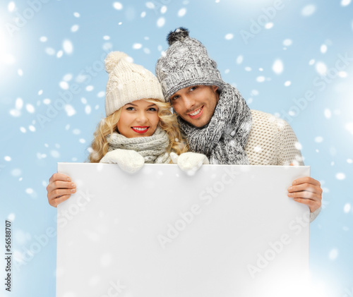 Photo: couple in a winter clothes holding blank board couple in a winter clothes holding blank board