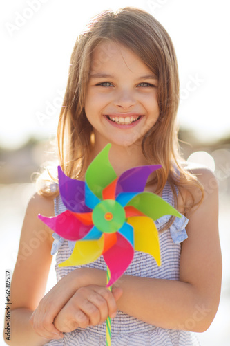 Photo: happy girl with colorful pinwheel toy happy girl with colorful pinwheel toy