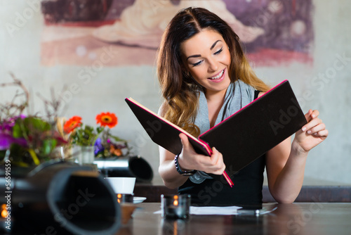 Photo: Woman in restaurant choosing food in menu Woman in restaurant choosing food in menu