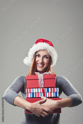 Photo: Smiling woman clutching a pile of Xmas gifts Smiling woman clutching a pile of Xmas gifts