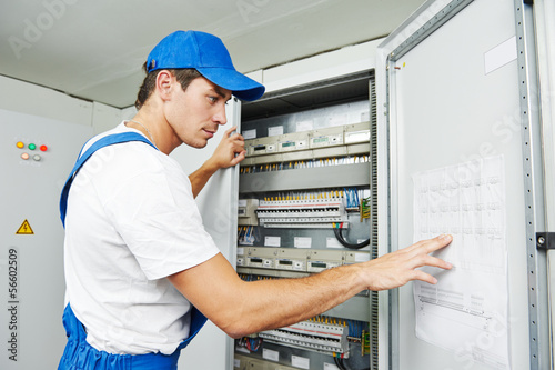 Photo: electrician worker inspecting electrician worker inspecting