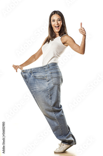 Photo: happy attractive girl posing in huge pants with the thumbs up happy attractive girl posing in huge pants with the thumbs up