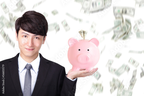 Photo: business man holding pink piggy bank business man holding pink piggy bank
