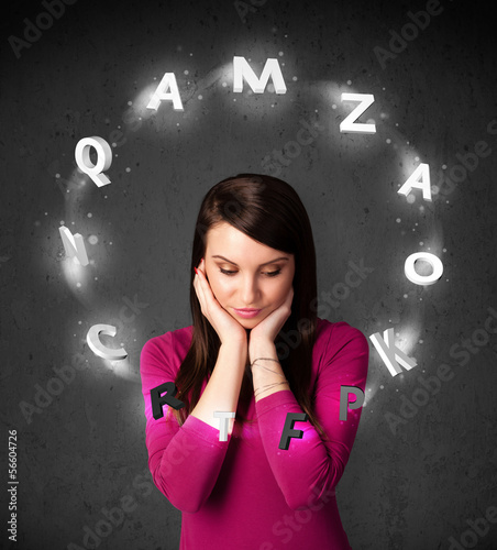 Photo: Young woman thinking with letter circulation around her head Young woman thinking with letter circulation around her head