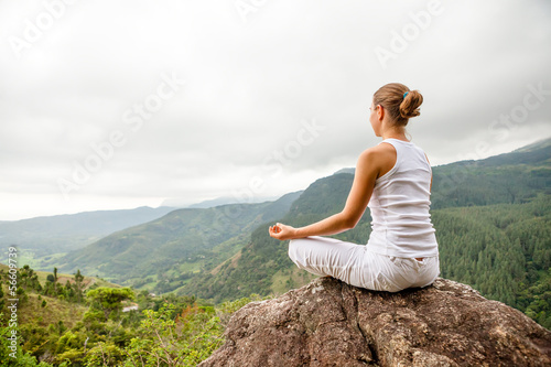 Photo: Woman is doing yoga exercises in mountains Woman is doing yoga exercises in mountains