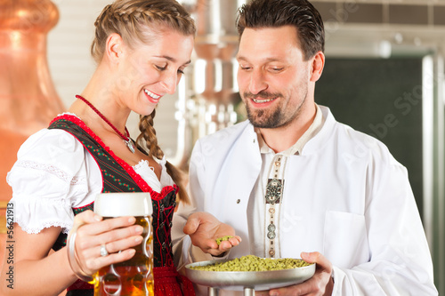 Photo: brewer and woman with beer glass in brewery brewer and woman with beer glass in brewery