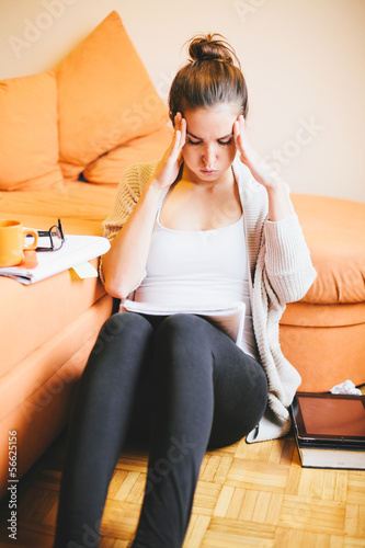 Photo: Stressed young woman studying at home Stressed young woman studying at home
