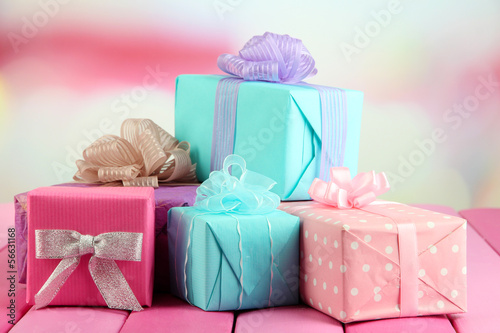 Photo: Beautiful bright gifts, on bright wooden table Beautiful bright gifts, on bright wooden table
