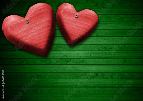 Illustration: Red Wooden Hearts on Green Wood Background Red Wooden Hearts on Green Wood Background