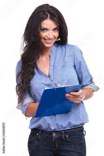 Photo: casual woman writes on clipboard casual woman writes on clipboard